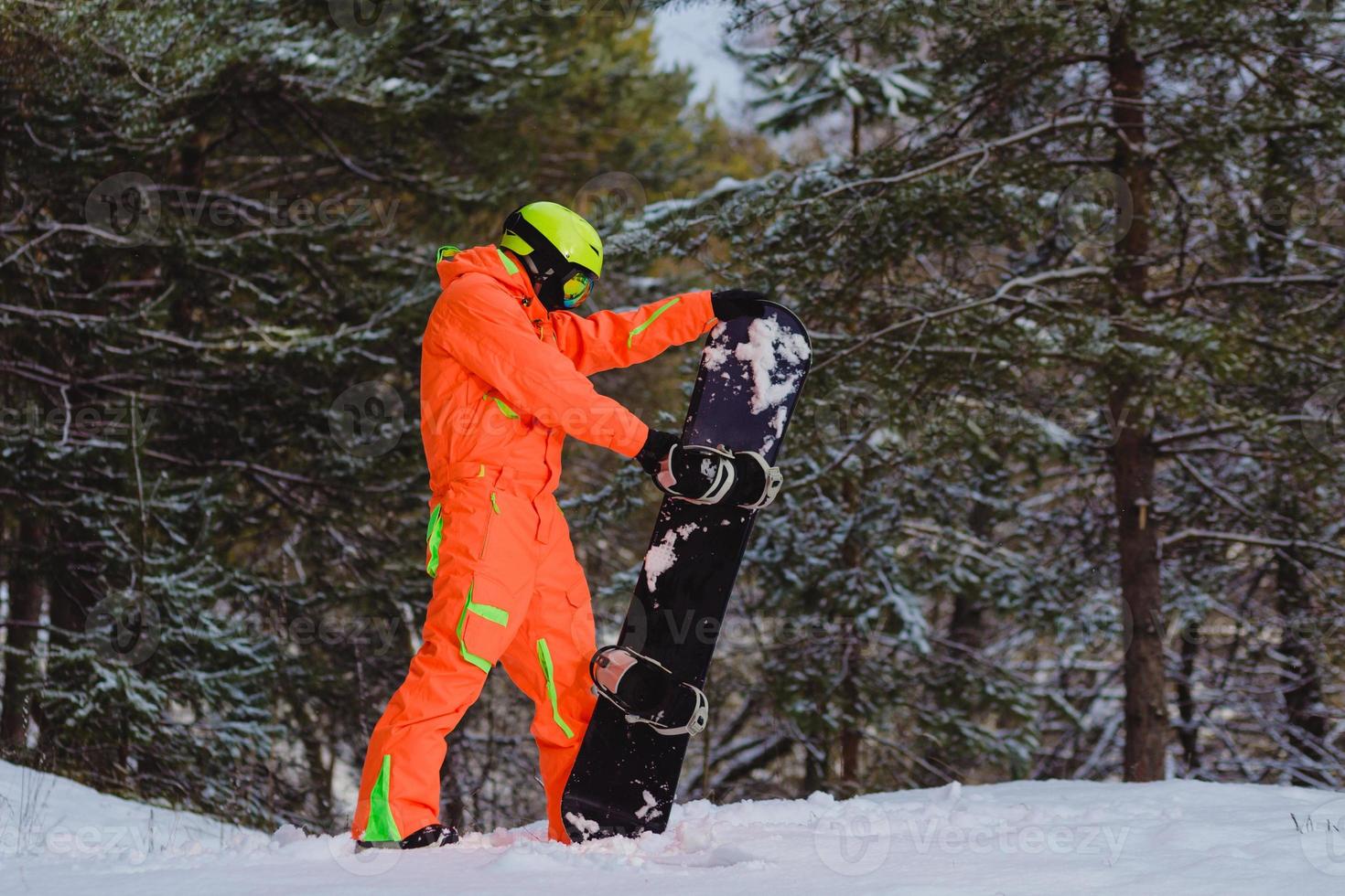 Snowboarder checks his equipment photo