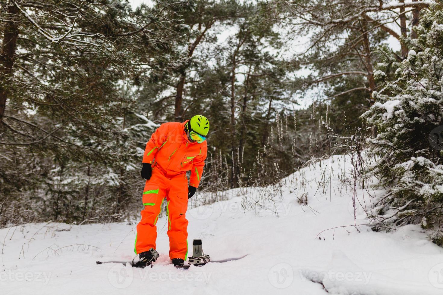 Snowboarder checks his equipment photo