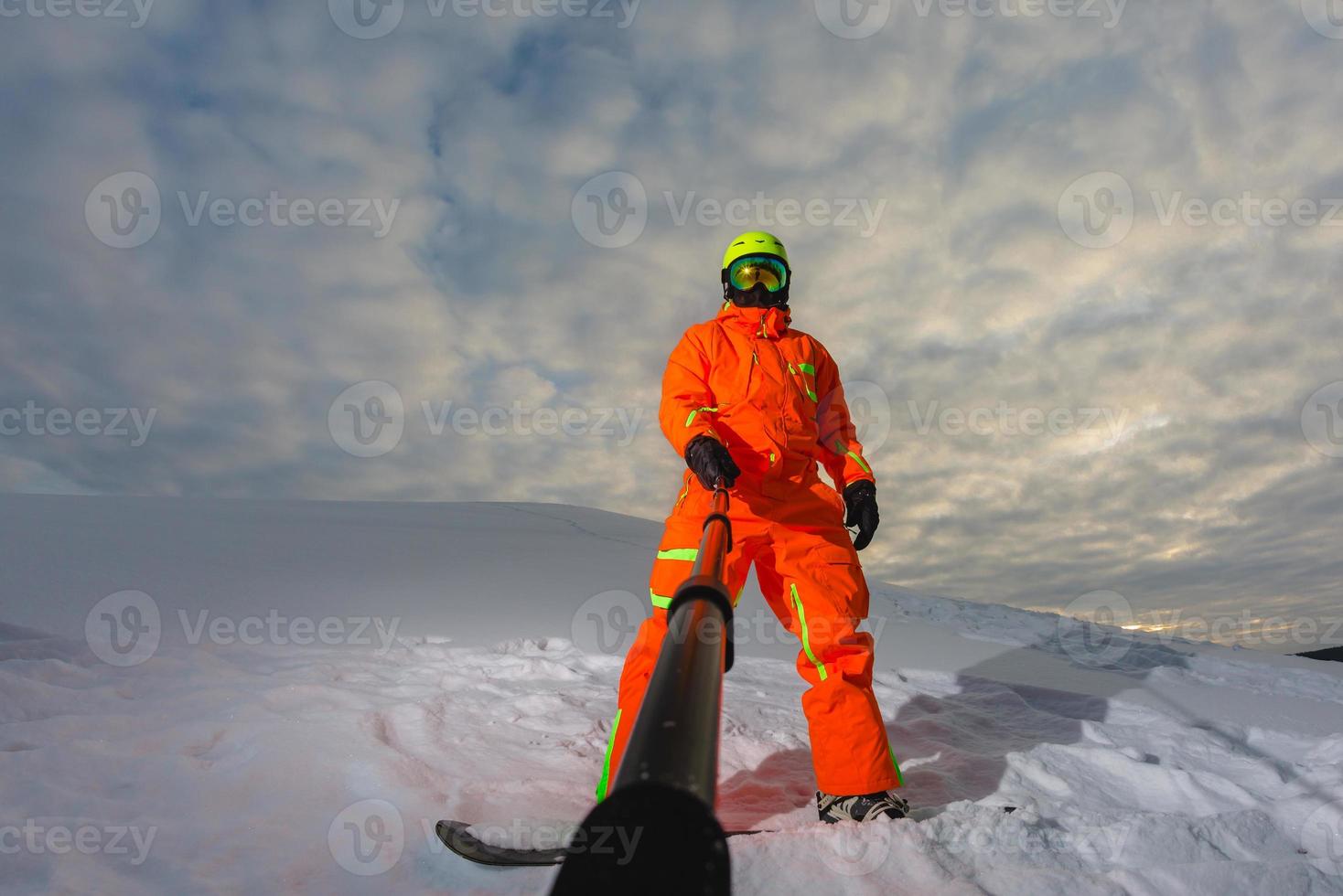 Snowboarder with the snowboard making a selfie photo