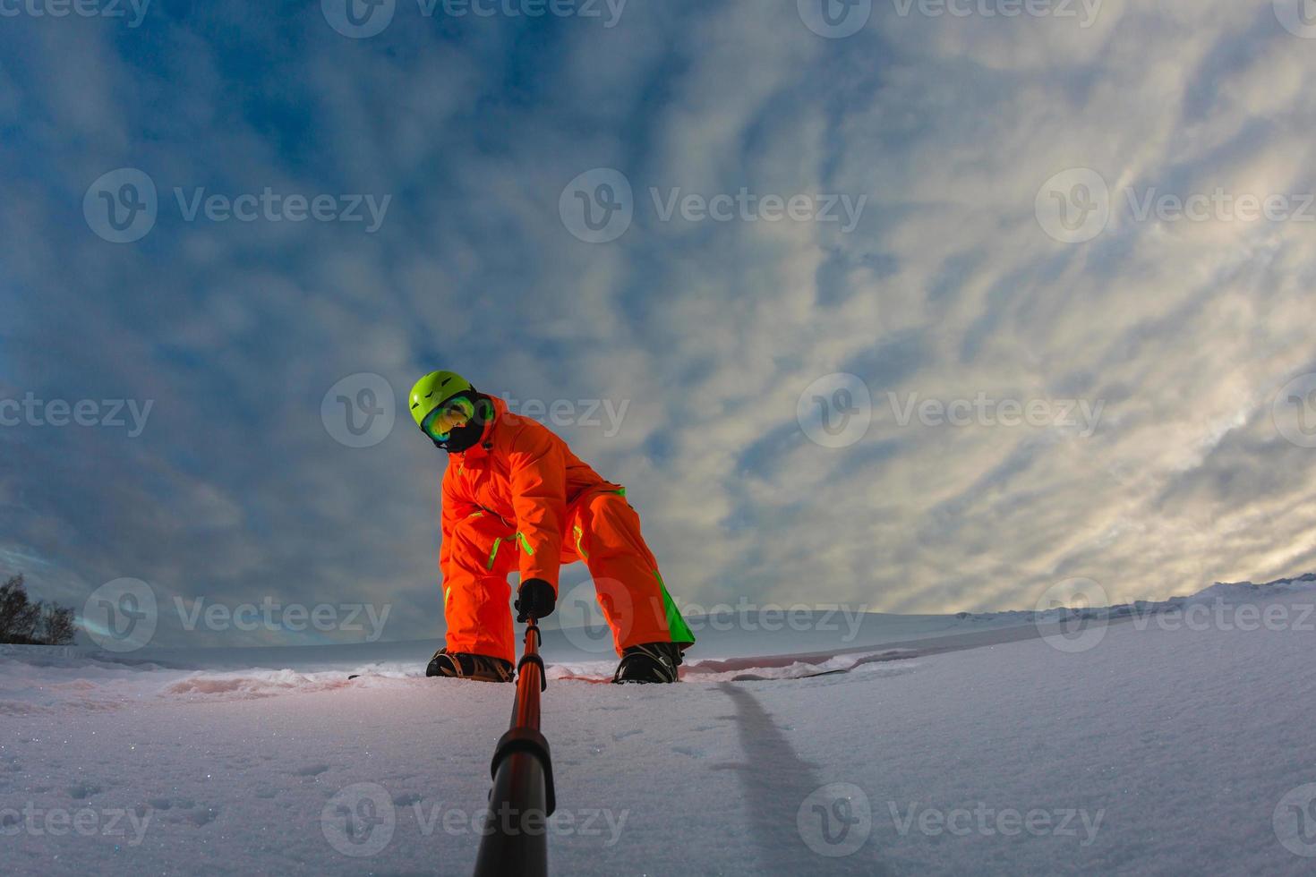 Snowboarder with the snowboard making a selfie photo