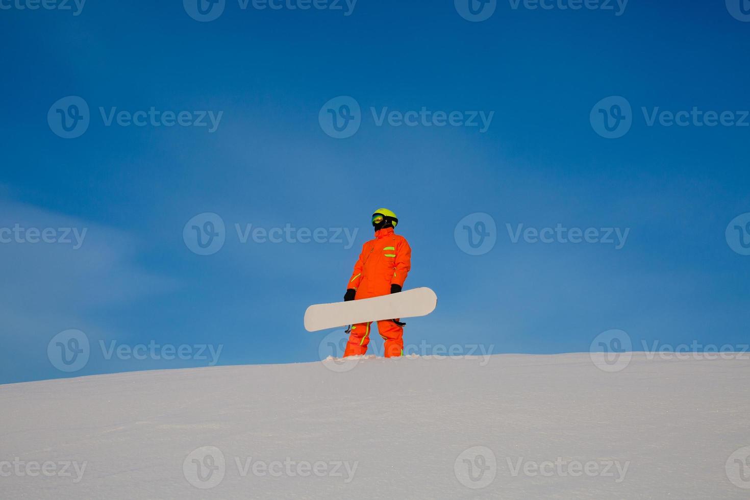 Snowboarder freerider with white snowboard sitting on the top of the ski slope photo