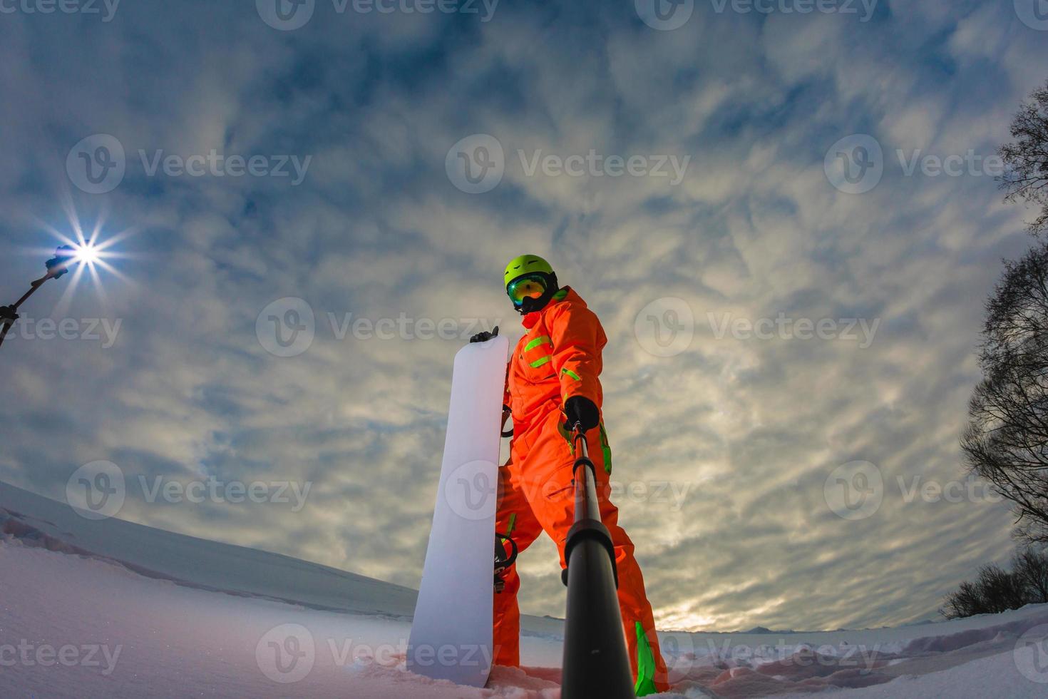 Snowboarder with the snowboard making a selfie photo