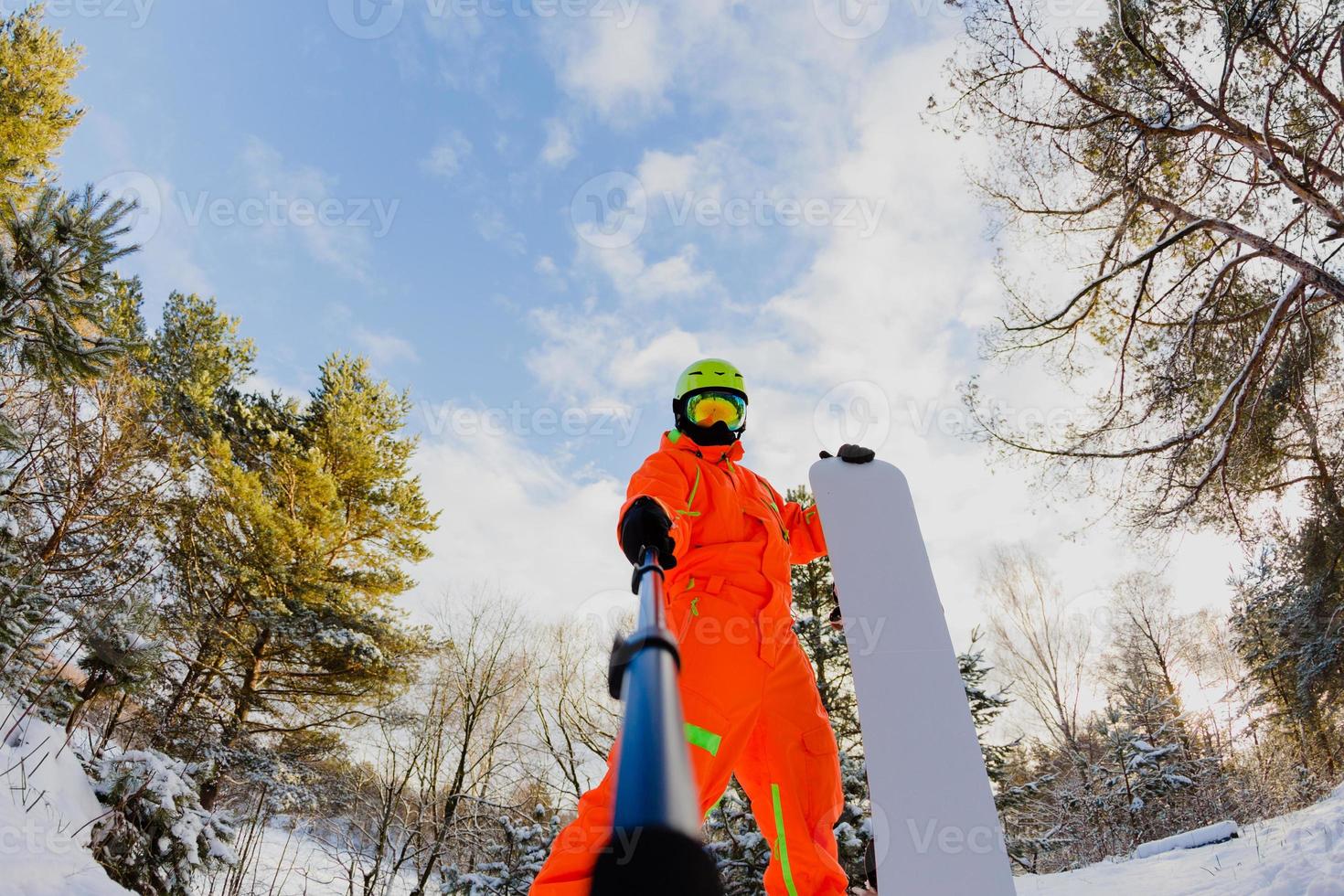 Snowboarder with the snowboard making a selfie photo