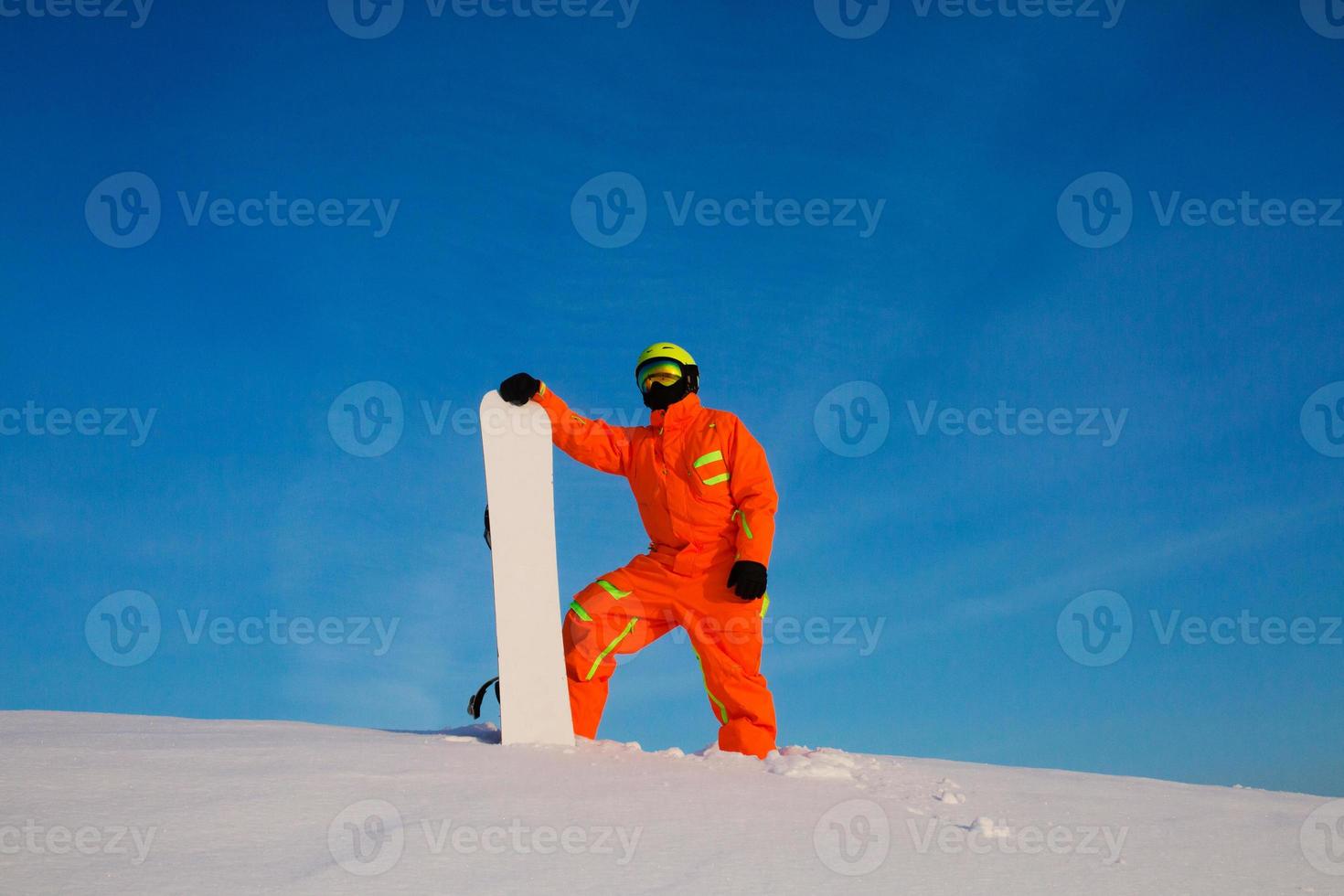 Snowboarder freerider with white snowboard standing on the top of the ski slope photo