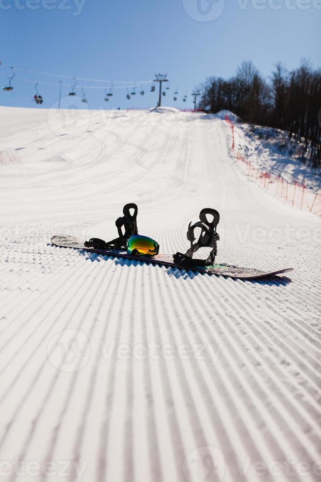 Bottom view on empty ski slope and equipment for snowboarding photo