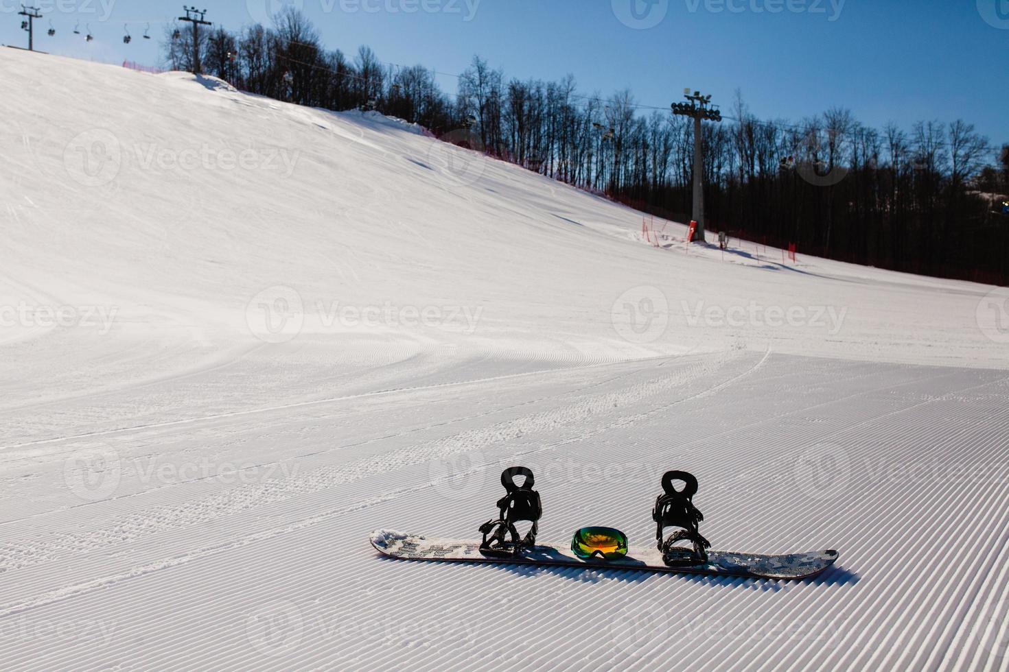 Bottom view on empty ski slope and equipment for snowboarding photo