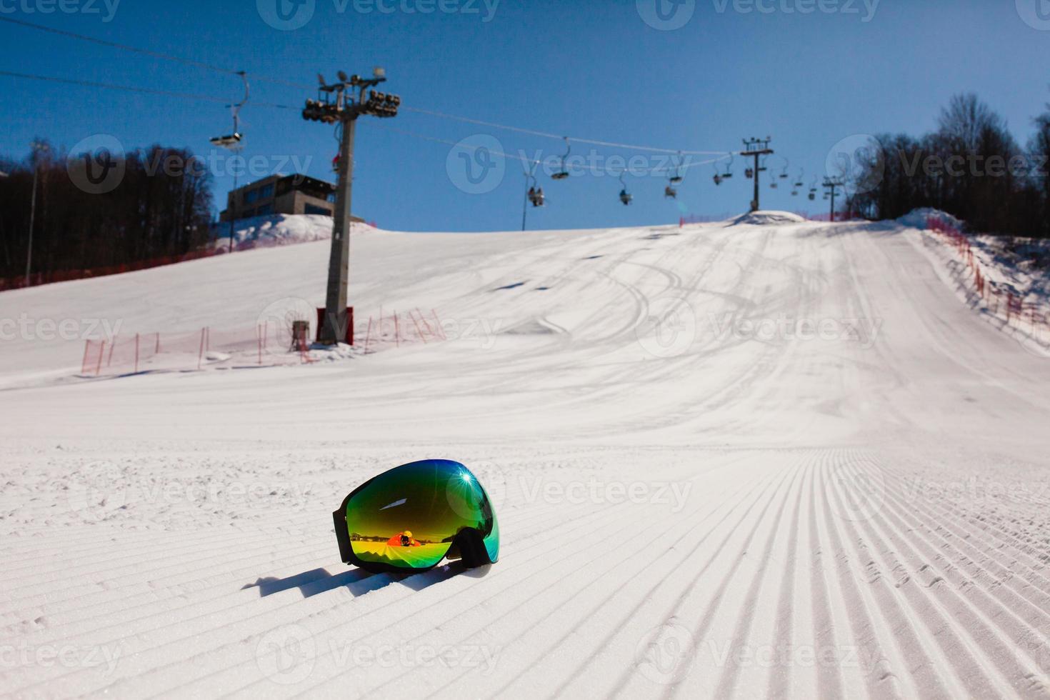 Bottom view on empty ski slope and equipment for snowboarding photo