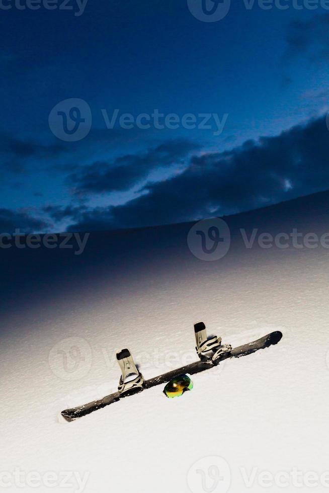 Powder texture and snowboard at sunset photo