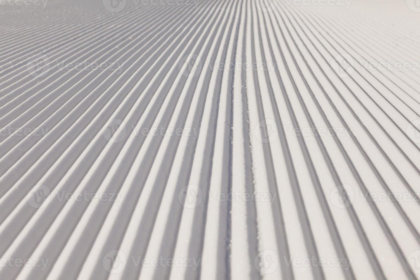 Texture of new groomed snow on empty ski slope photo