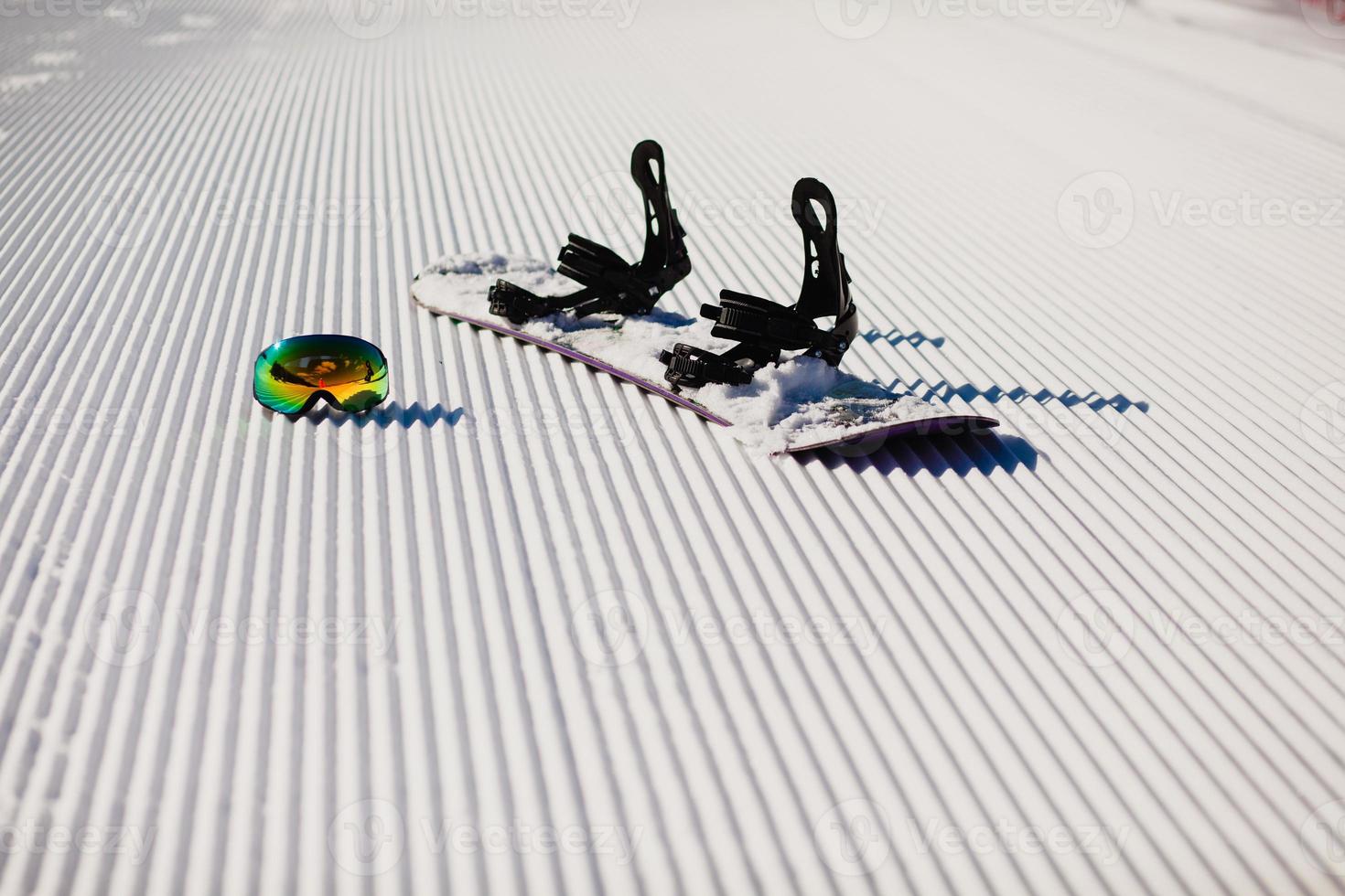 Equipment for snowboarding on a new groomed snow photo