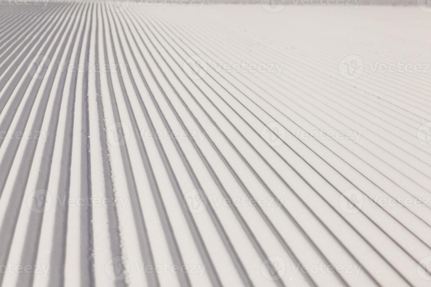 Texture of new groomed snow on empty ski slope photo