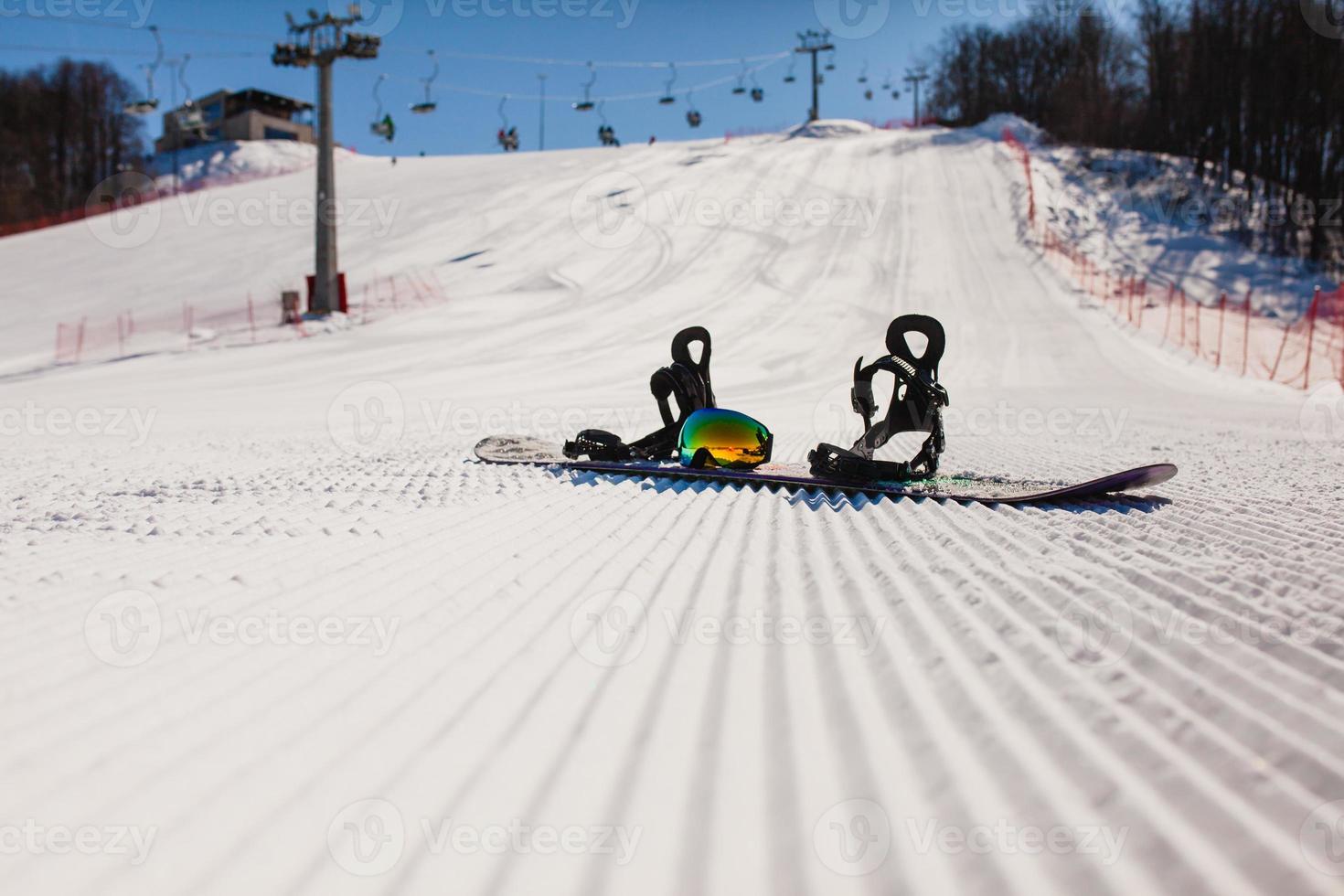 Bottom view on empty ski slope and equipment for snowboarding photo