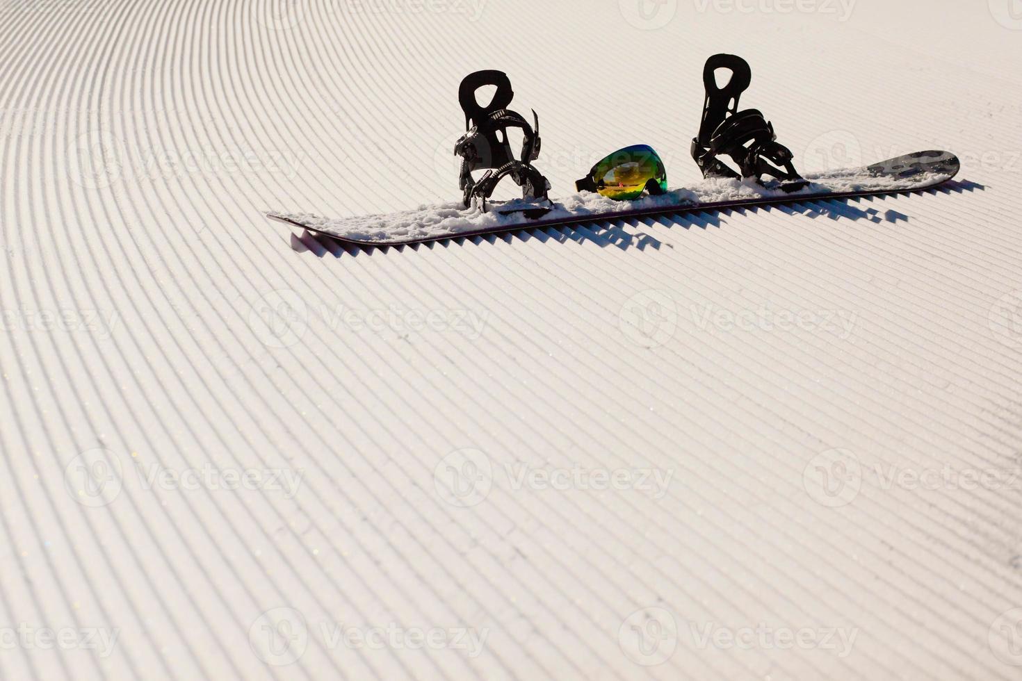 Equipo para hacer snowboard en una nueva nieve preparada. foto