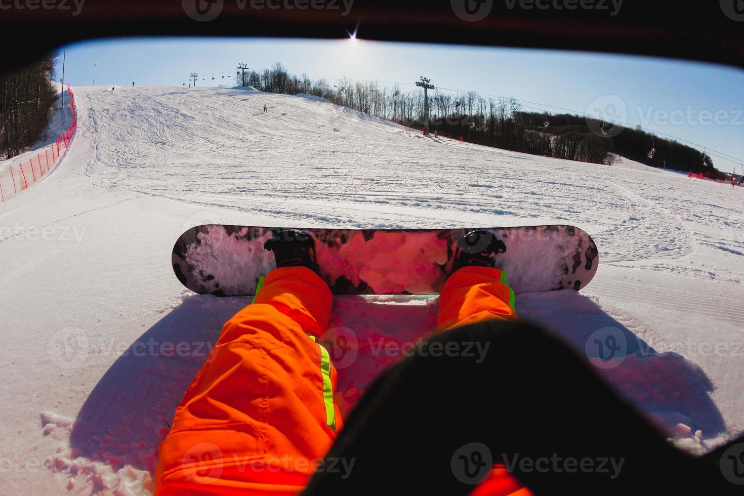 Punto de vista de un hombre snowboarder sentado en la nieve. foto