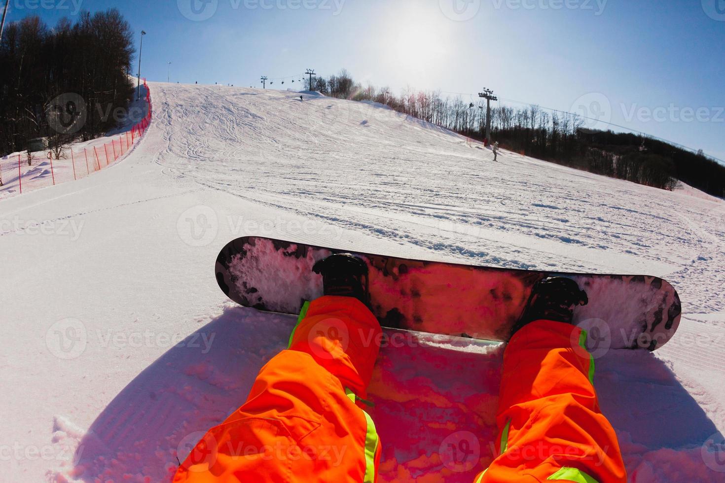 Point of view shot of a male snowboarder sitting on the snow photo