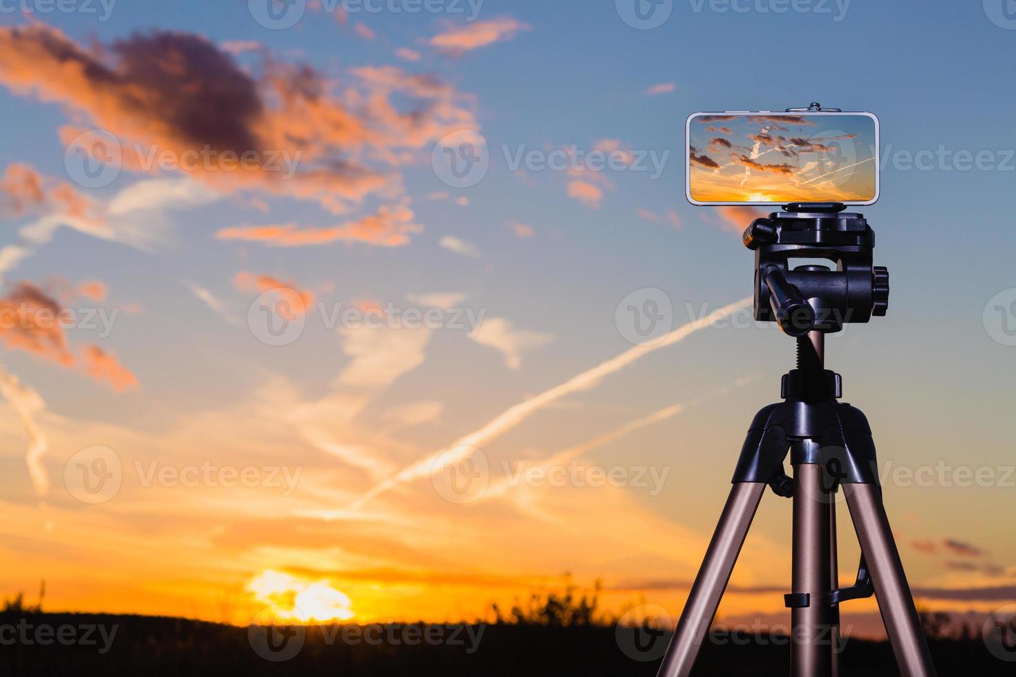 Smartphone on tripod capturing image of stunning sundown photo