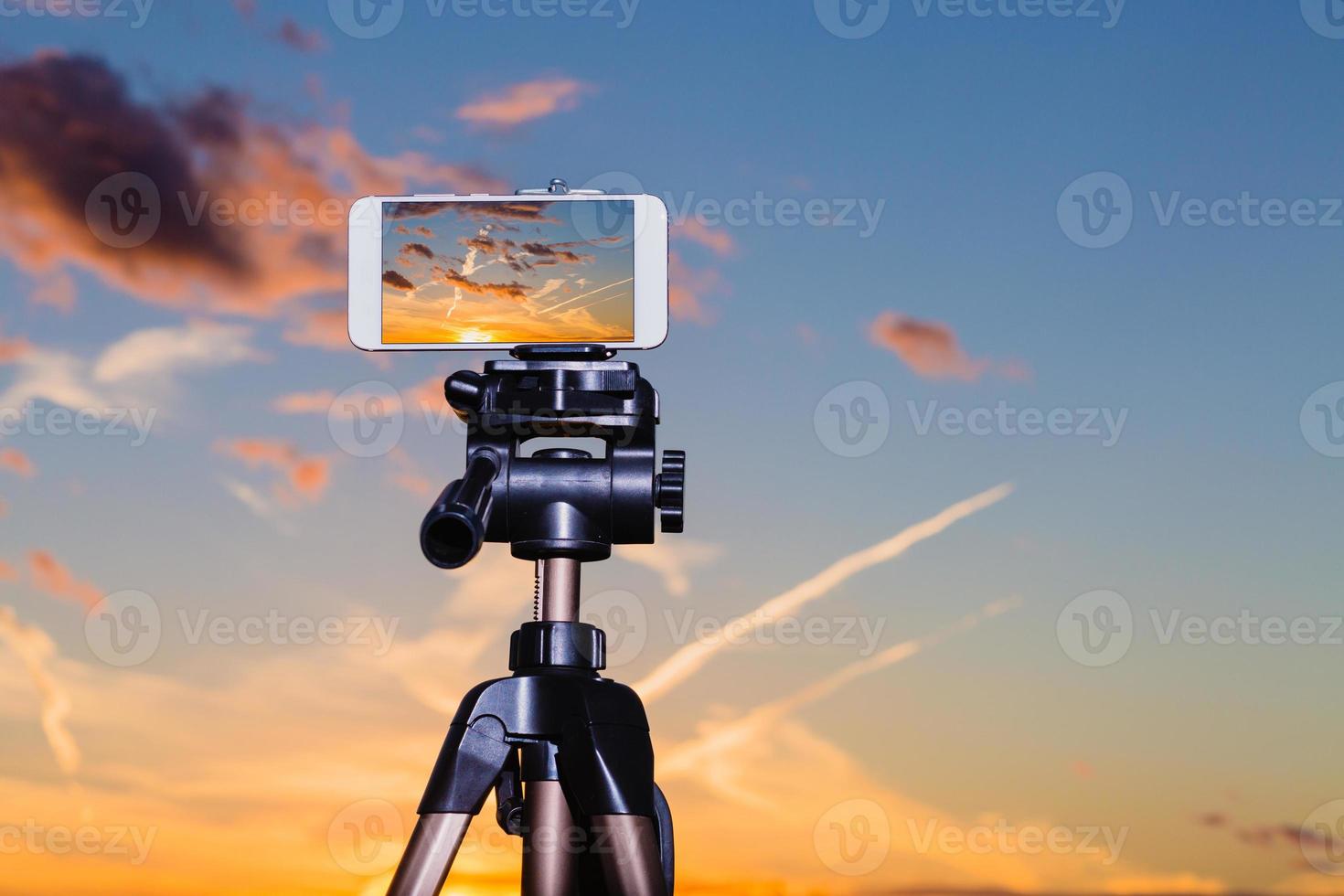 Smartphone on tripod capturing image of stunning sundown photo