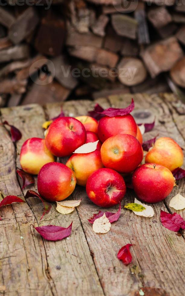 Bodegón con varias manzanas rojas sobre una vieja mesa de madera foto