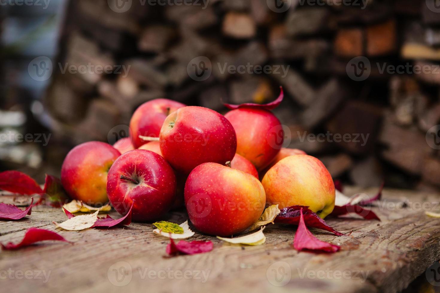 Bodegón con varias manzanas rojas sobre una vieja mesa de madera foto