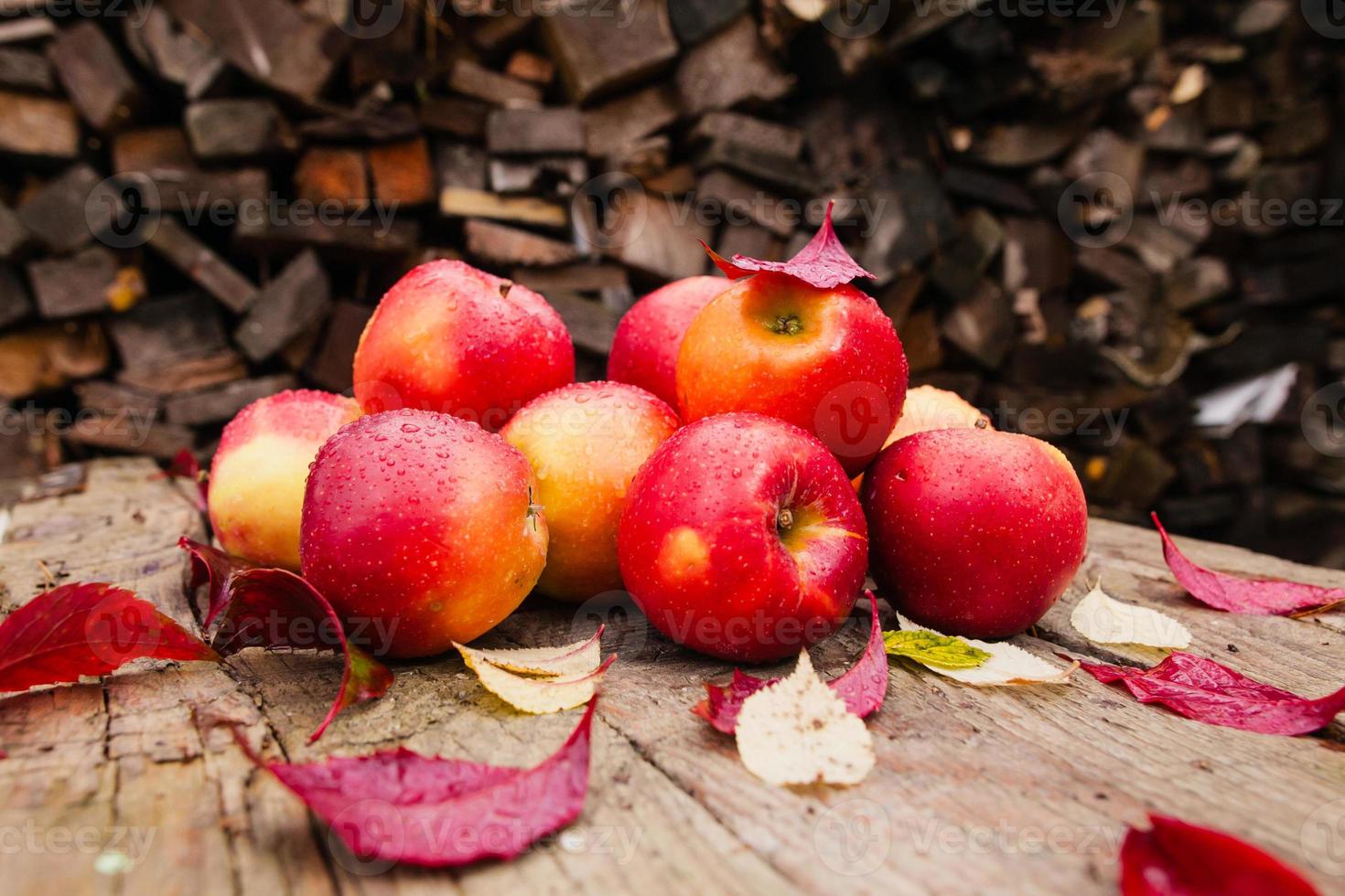 Bodegón con varias manzanas rojas sobre una vieja mesa de madera foto