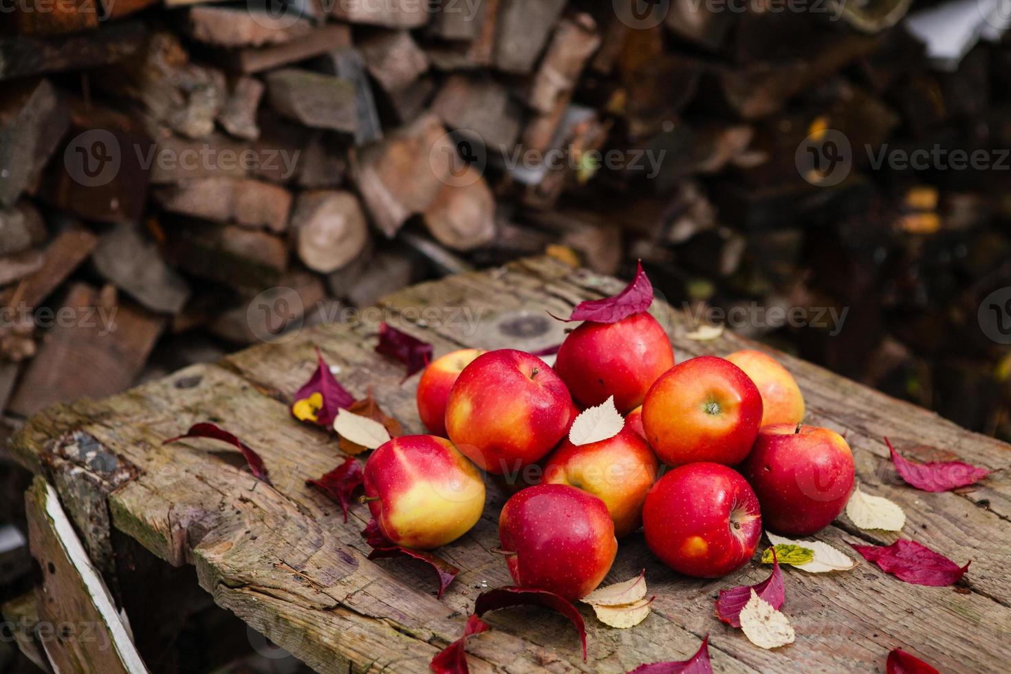 Bodegón con varias manzanas rojas sobre una vieja mesa de madera foto