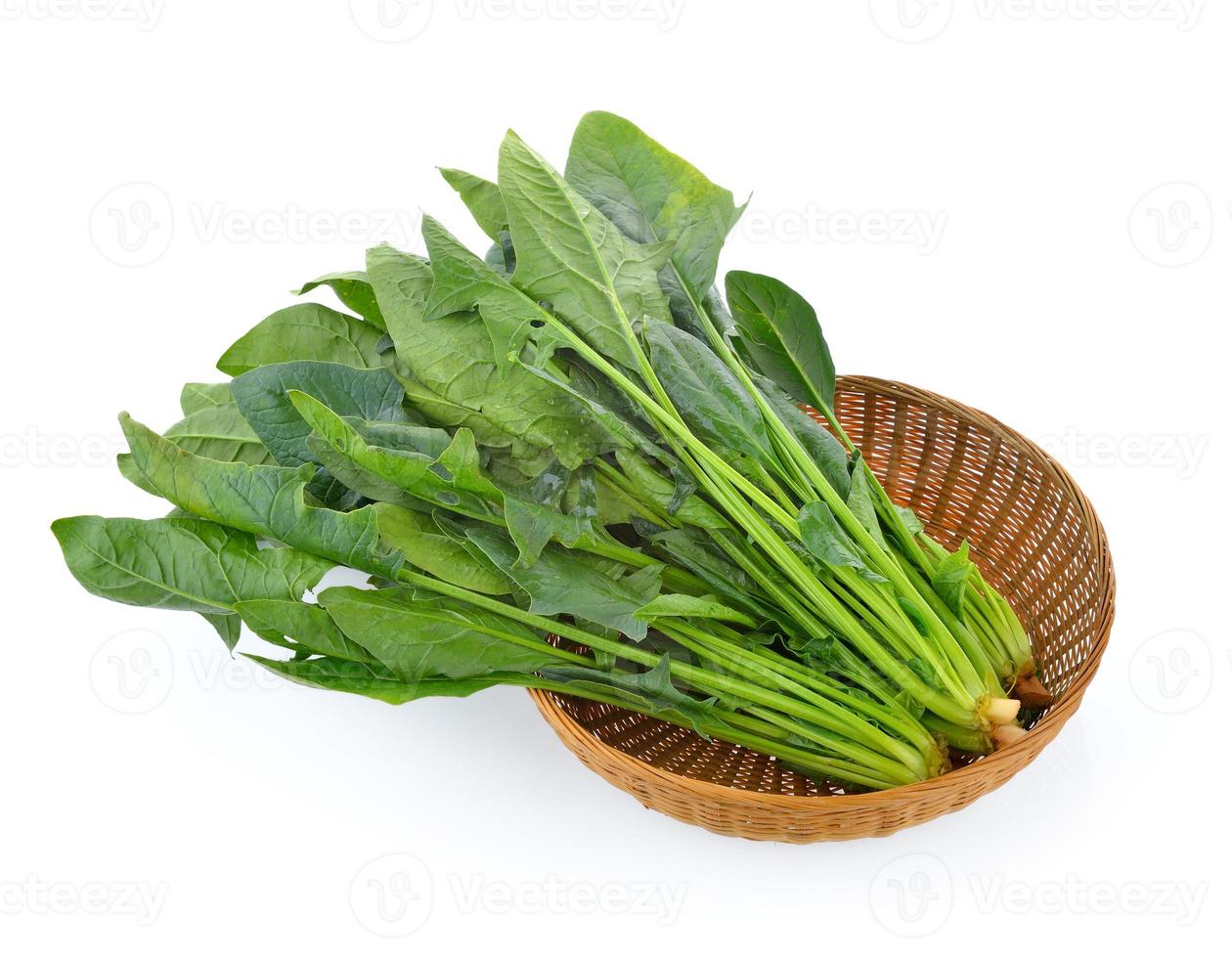 Spinach leaves in basket isolated on white background photo