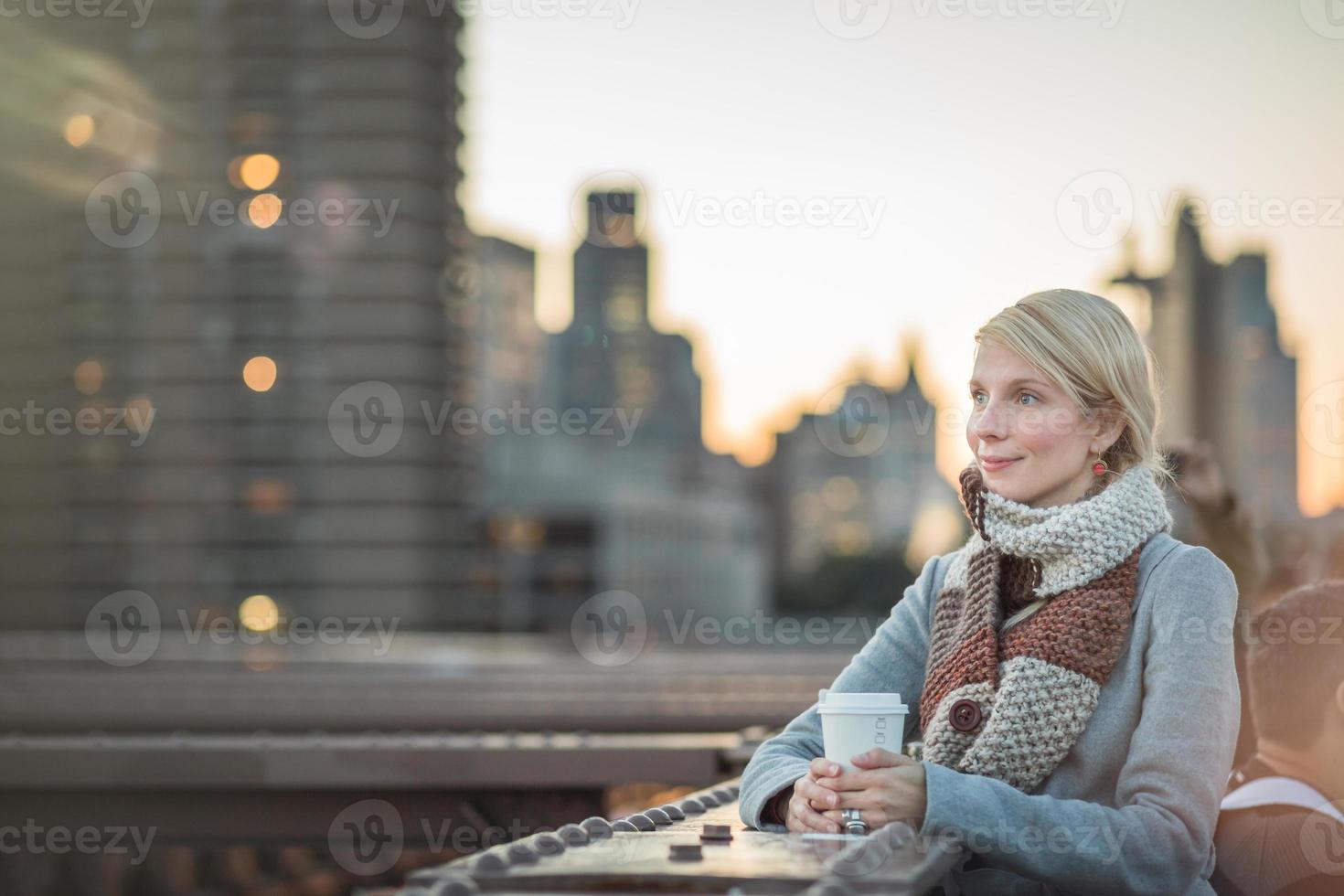 Woman on the Brooklyn Bridge Looking at Manhattan with a Coffee photo