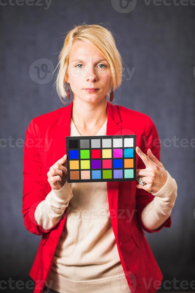 Blonde woman holding color board photo