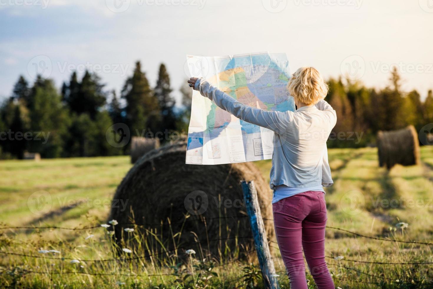 Mujer perdida en una escena rural mirando un mapa foto