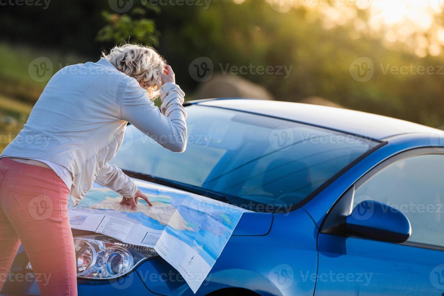 Mujer pensativa en una escena rural mirando un mapa foto