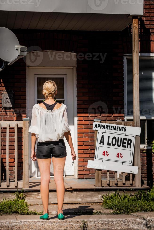 Young Woman standing in front of her new apartment photo