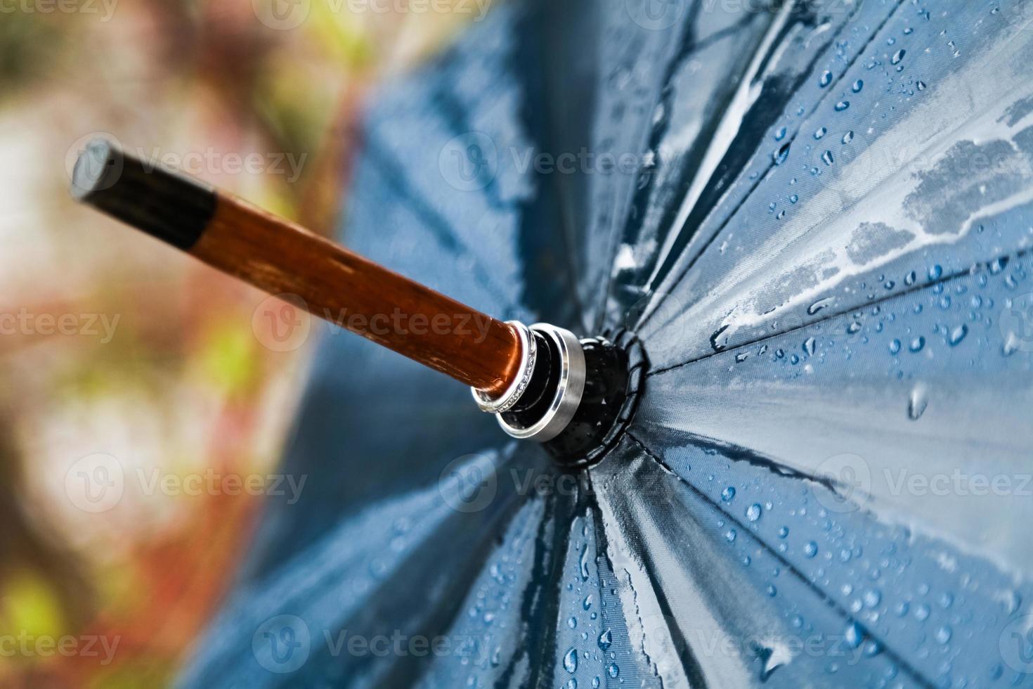 paraguas y alianzas de boda bajo la lluvia. foto