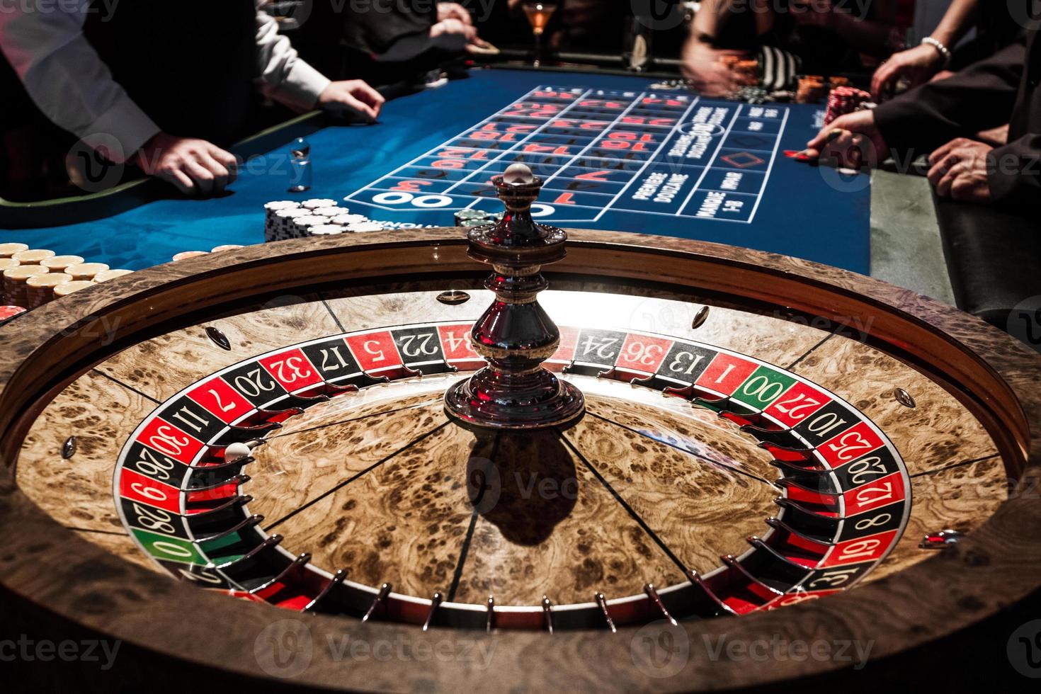 Detalles de la ruleta de madera brillante en un casino y personas foto