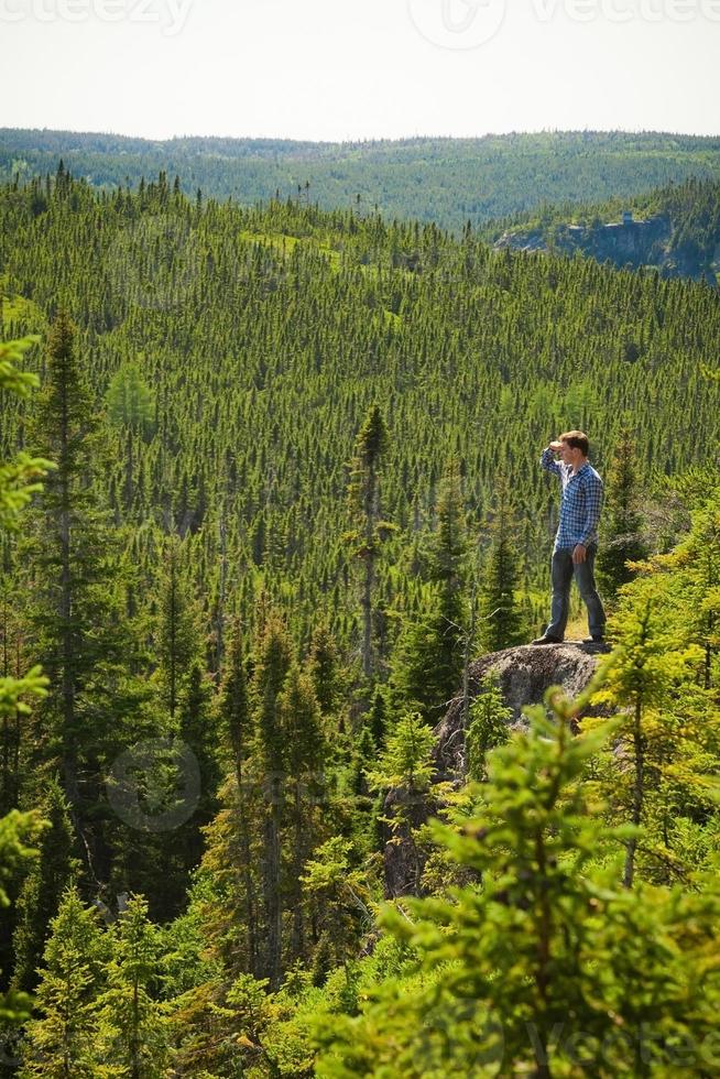 Young man on a rock in the middle of the nature photo