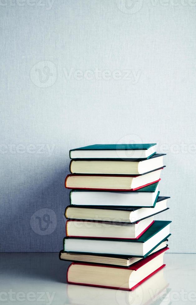 Stack of books on white reflective surface photo