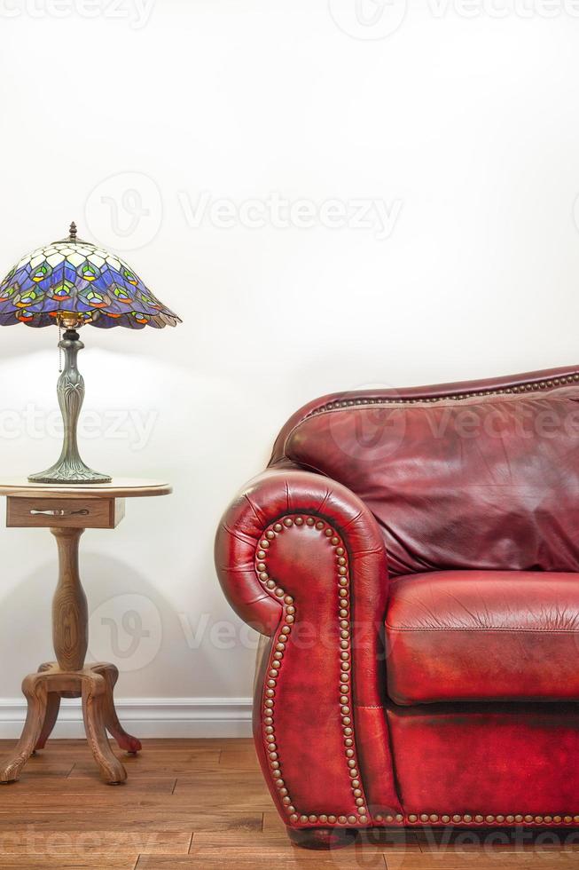 lujoso sofá de cuero rojo delante de una pared en blanco foto