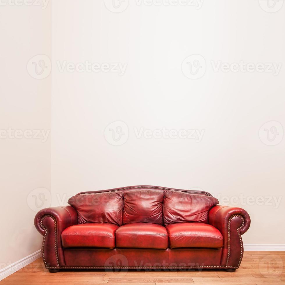 Luxurious Red Leather Couch in front of a blank wall photo