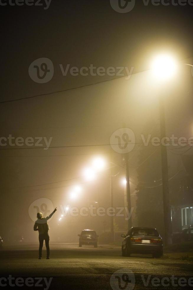 Woman alone in the foggy street photo