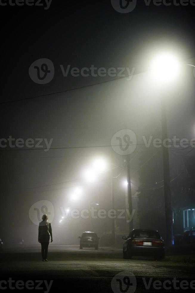 Woman alone in the foggy street photo