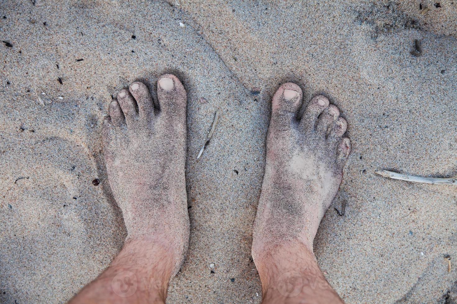 Men's feet in the sand photo