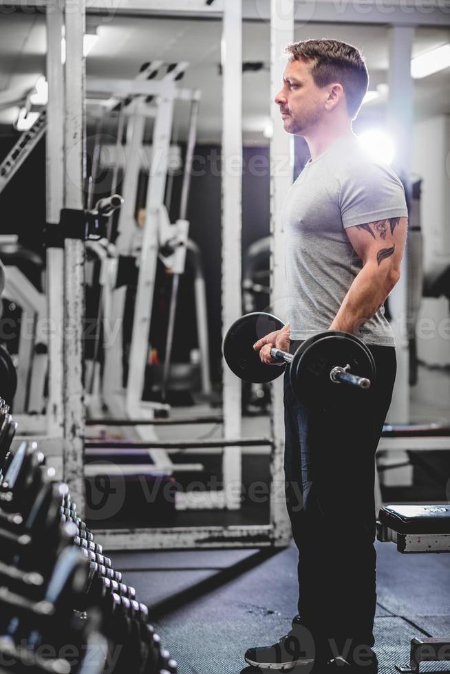 culturista levantando pesas en el gimnasio. foto