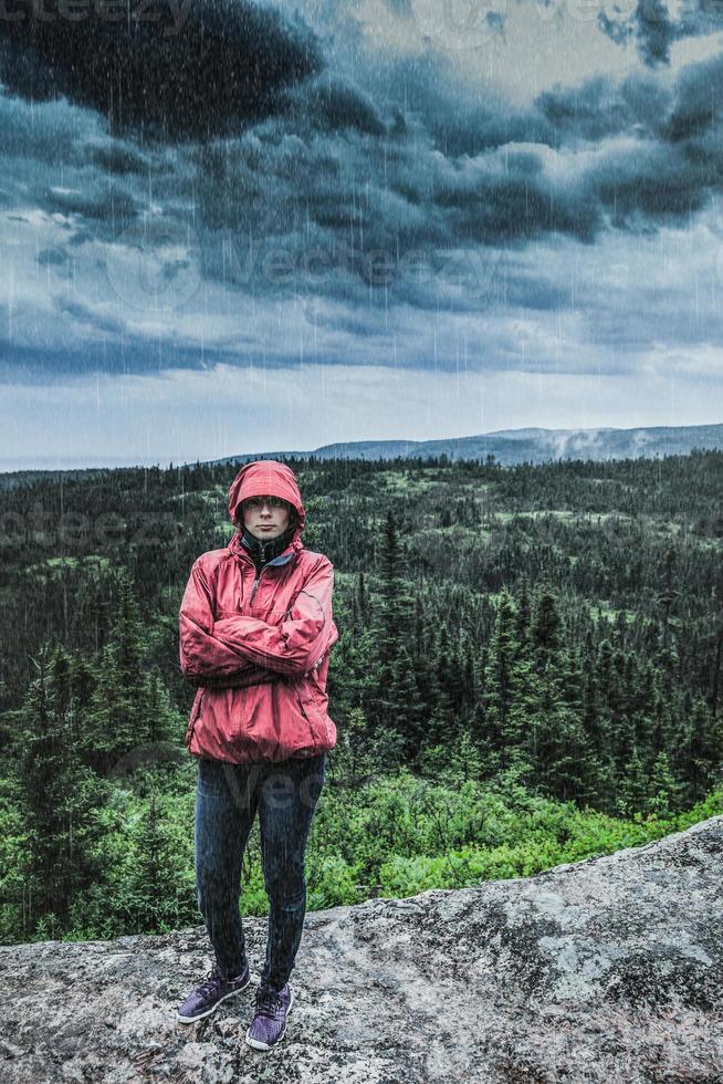 Unpredictable Heavy Rain Pouring on a Sad and Frustrated Young Woman Getting Cold photo