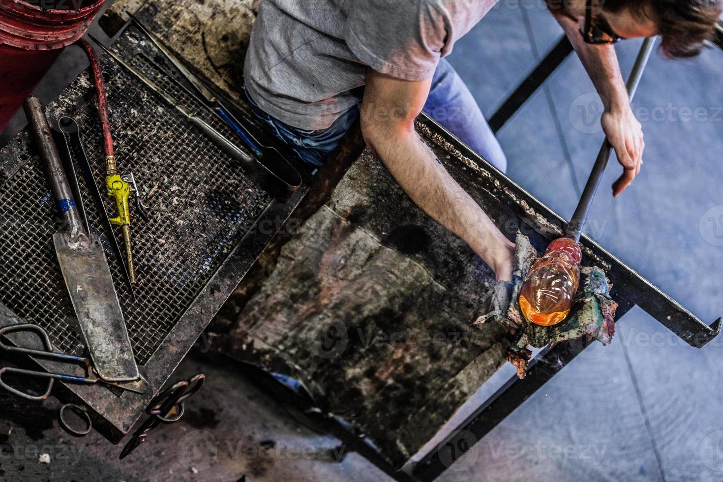 Man Hands Closeup Working on a Blown Glass Piece photo