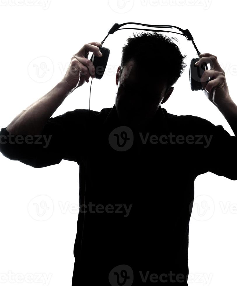 Male in silhouette putting headphones photo