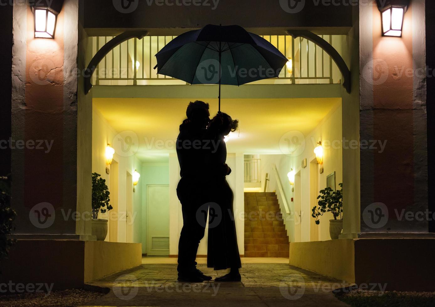 Couple in silhouette Kissing Under Umbrella photo