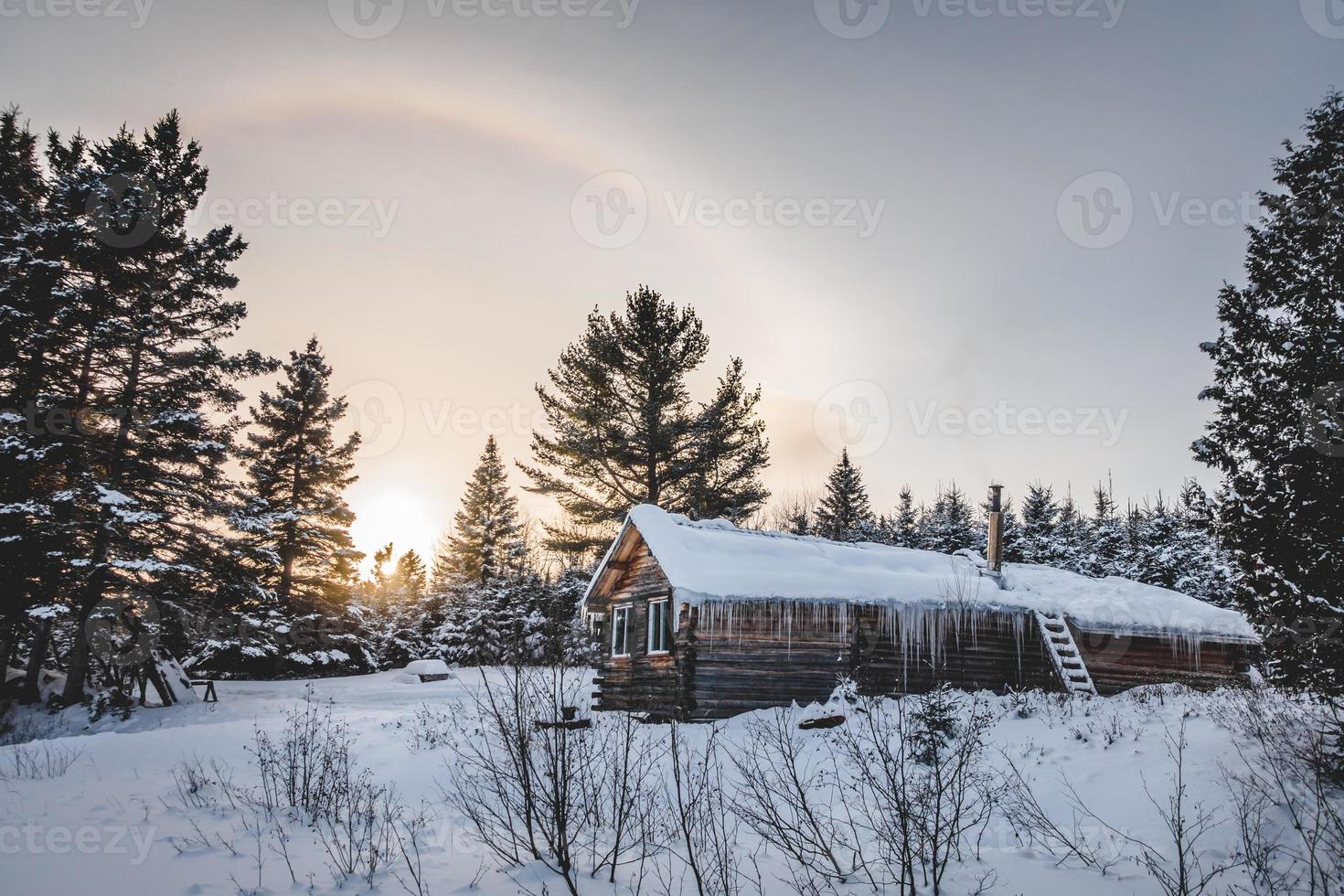 Cabaña de madera de troncos redondos canadienses durante el invierno foto