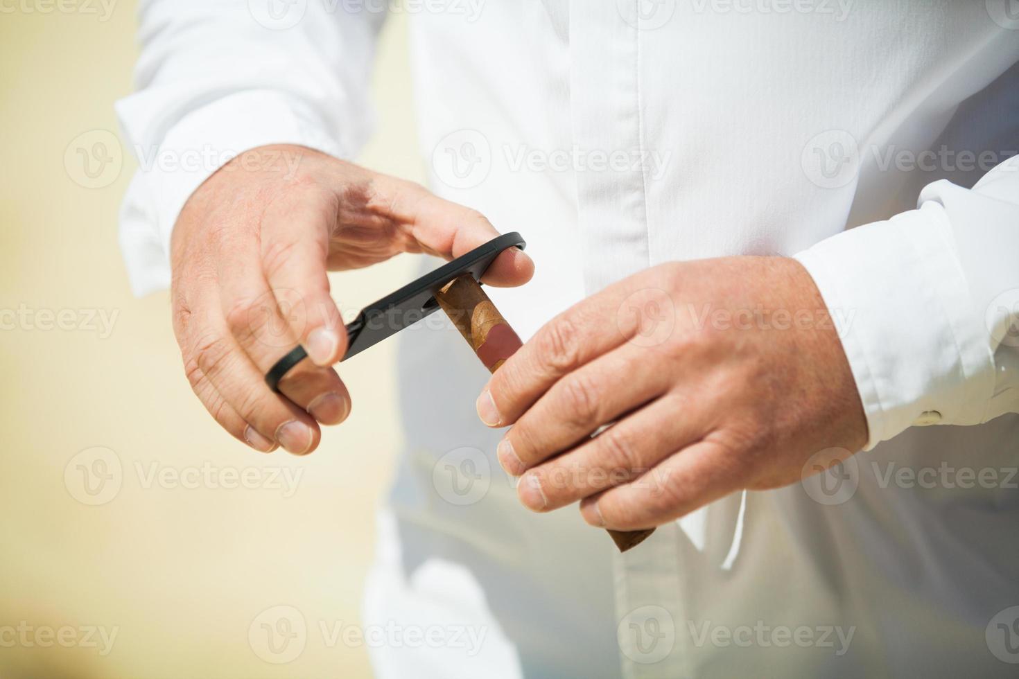 hombre cortando un cigarro foto