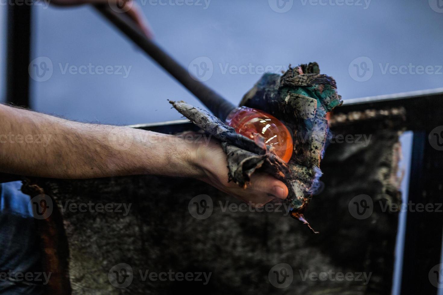 Man Hands Closeup Working on a Blown Glass Piece photo