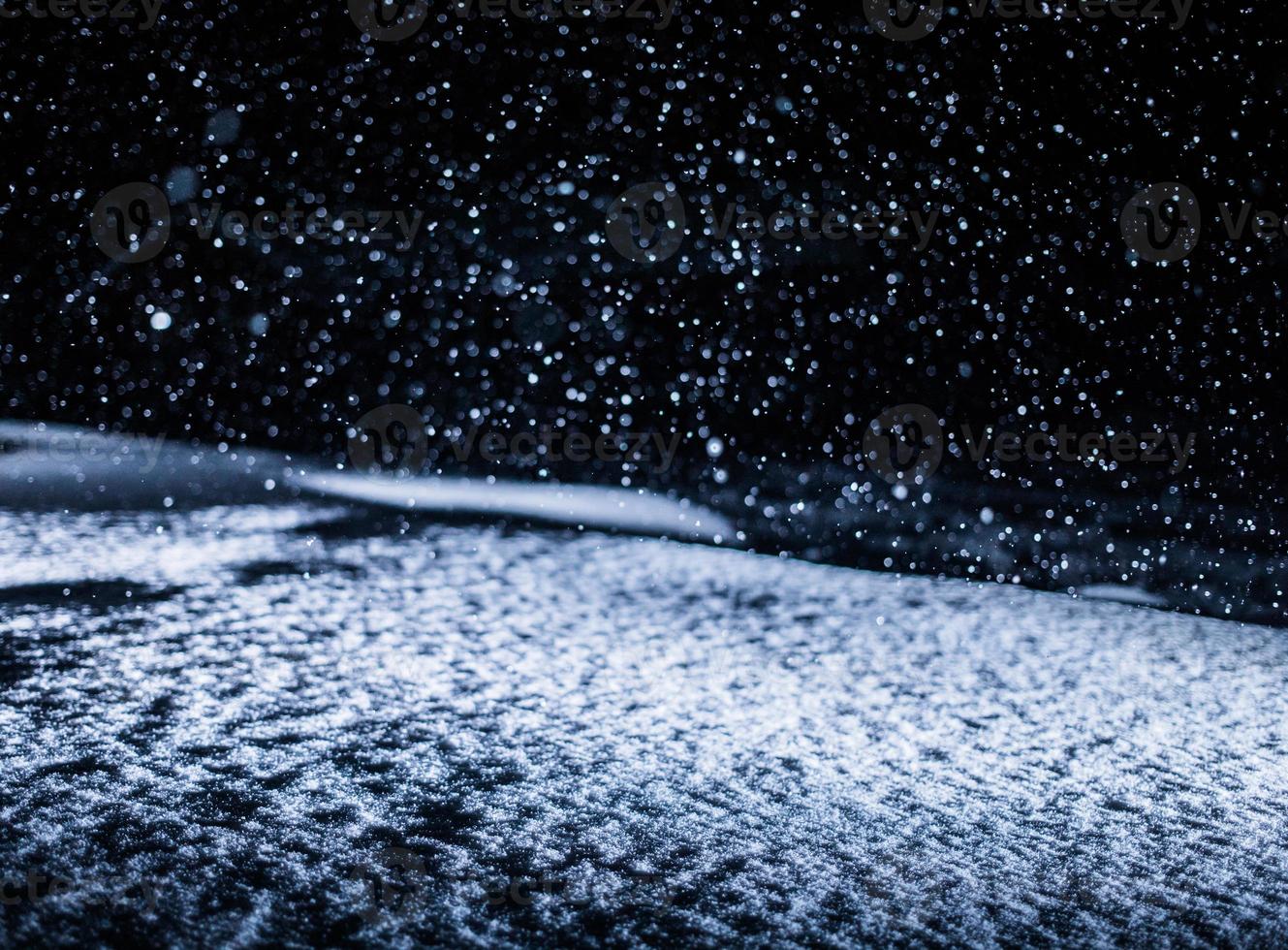 Textura de nieve retroiluminada durante la tormenta de nieve por la noche foto