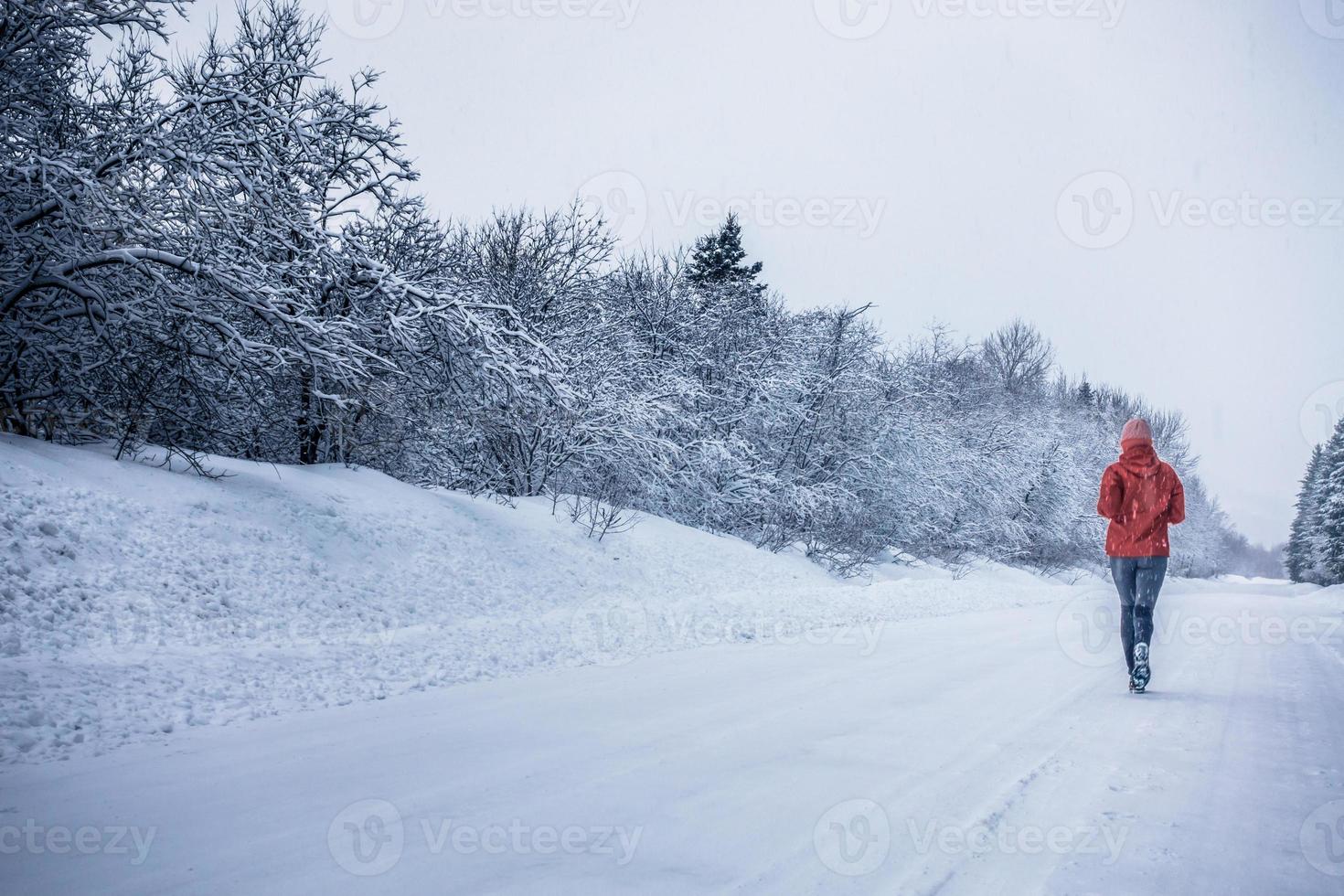 Mujer corriendo sola con el desenfoque de movimiento durante el frío día nevado de invierno en Canadá foto